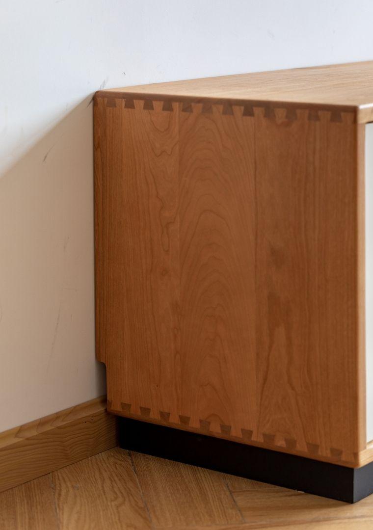 Wooden cabinet against a white wall with a wooden floor.