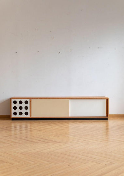 Modern wooden console table with decorative elements on a light wood floor.