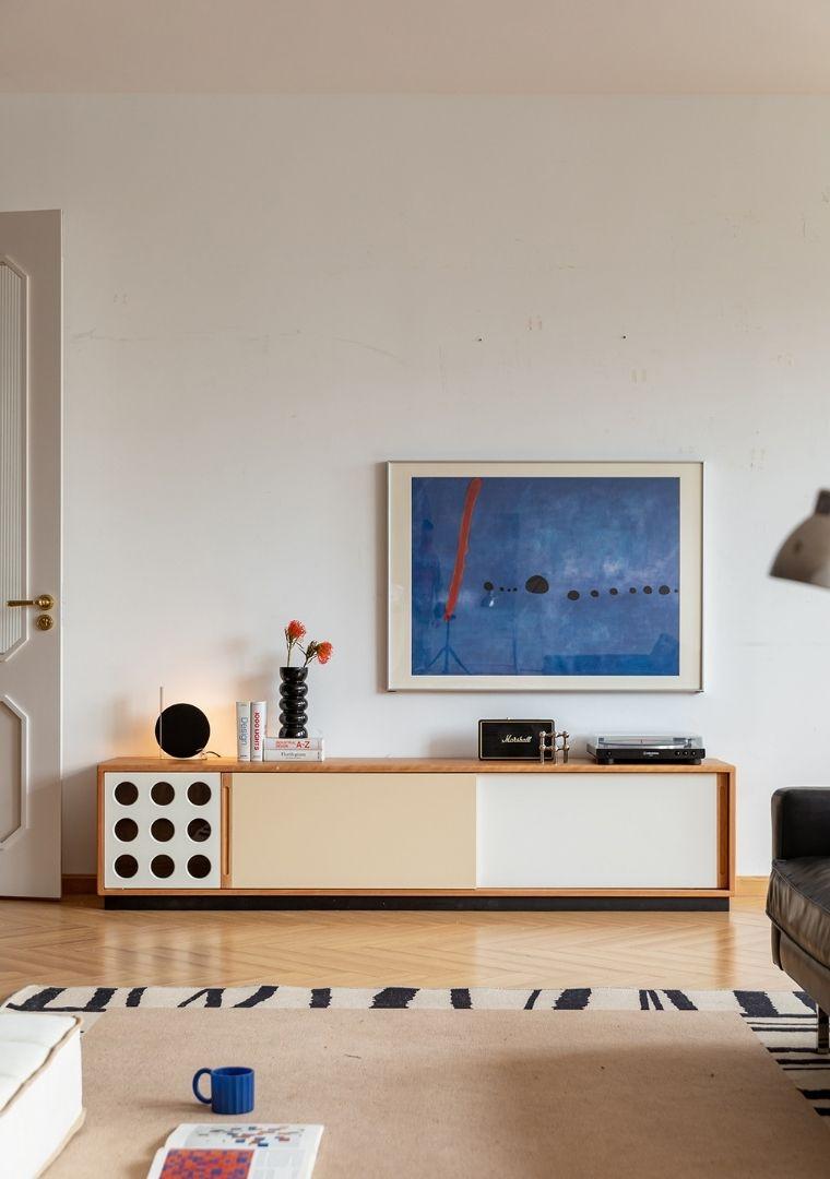 Modern living room with a sideboard, abstract painting, and decorative items.
