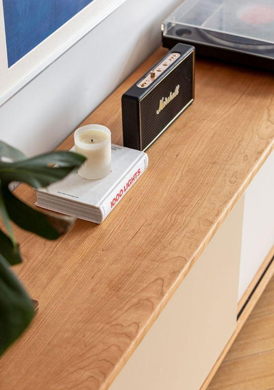 Marshall speaker on a wooden surface with a candle and book
