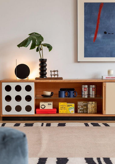 Wooden entertainment console with decorative items in a living room setting